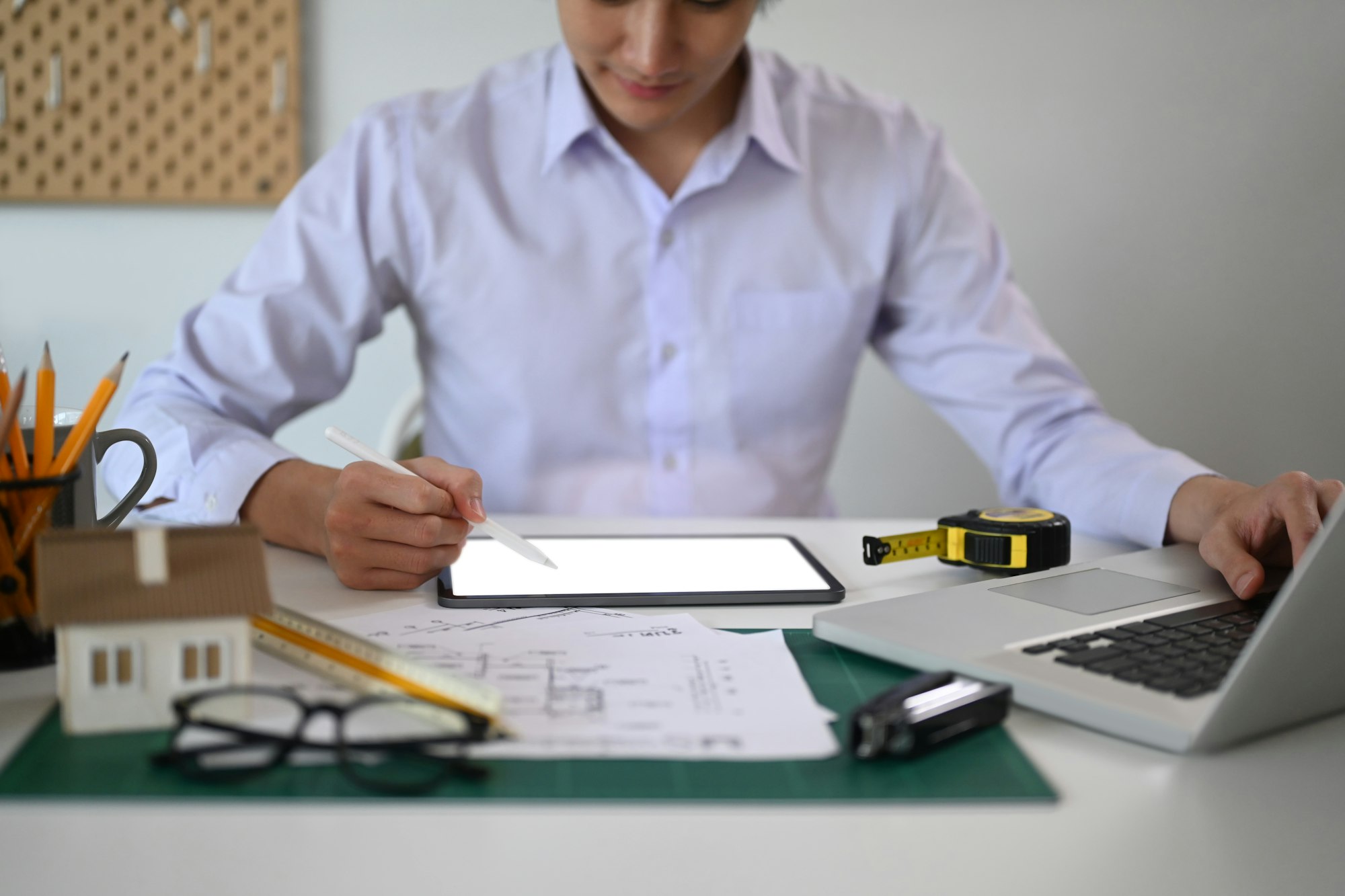 Engineer man using digital tablet and working with drawings inspection at office.