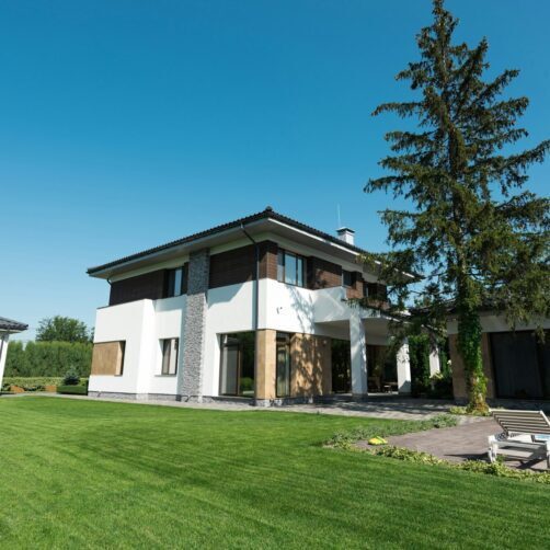 view of new modern house with swimming pool and green lawn